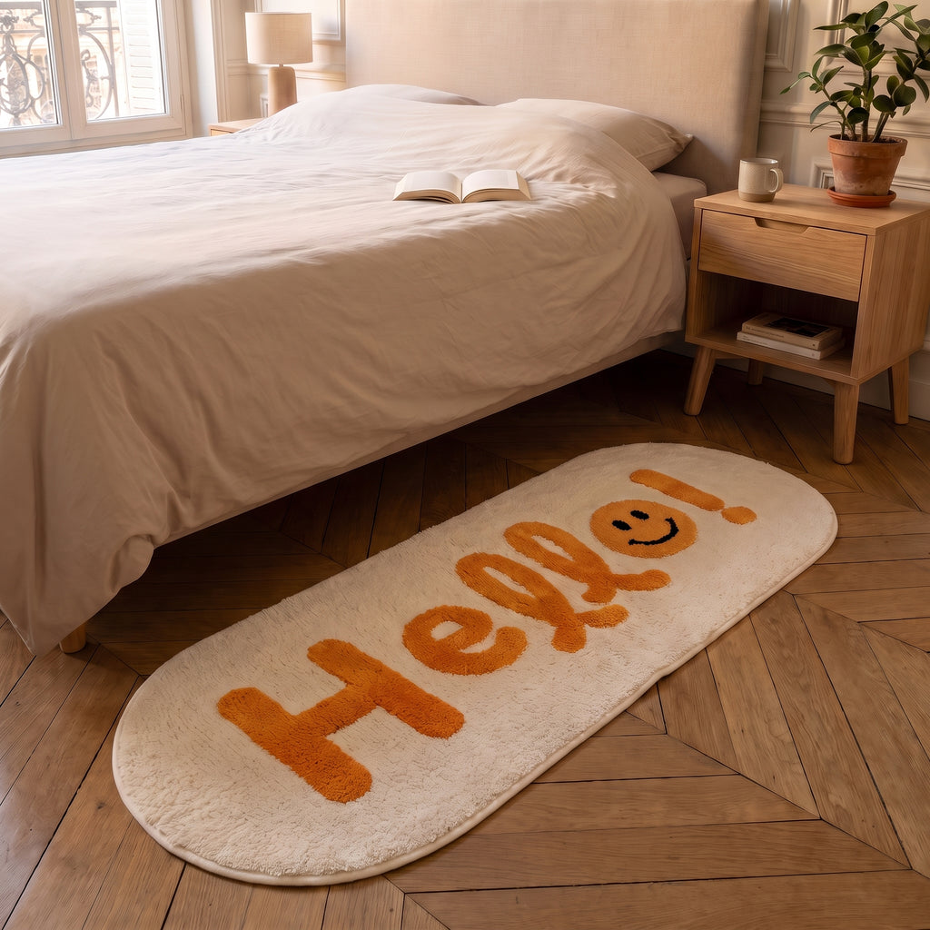 Tapis Hello posé le long du lit dans une chambre au parquet en point de Hongrie
