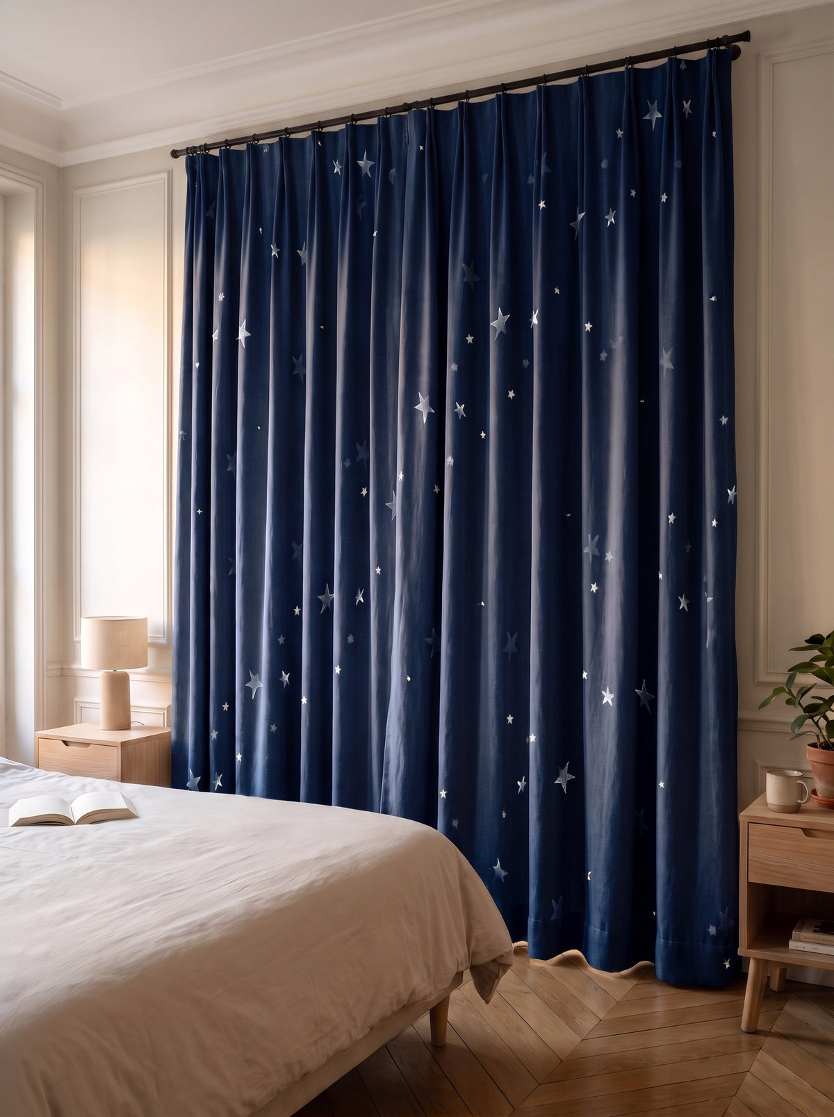 Rideau à étoiles argentées bleu marine, pan fermé devant la fenêtre d'une chambre