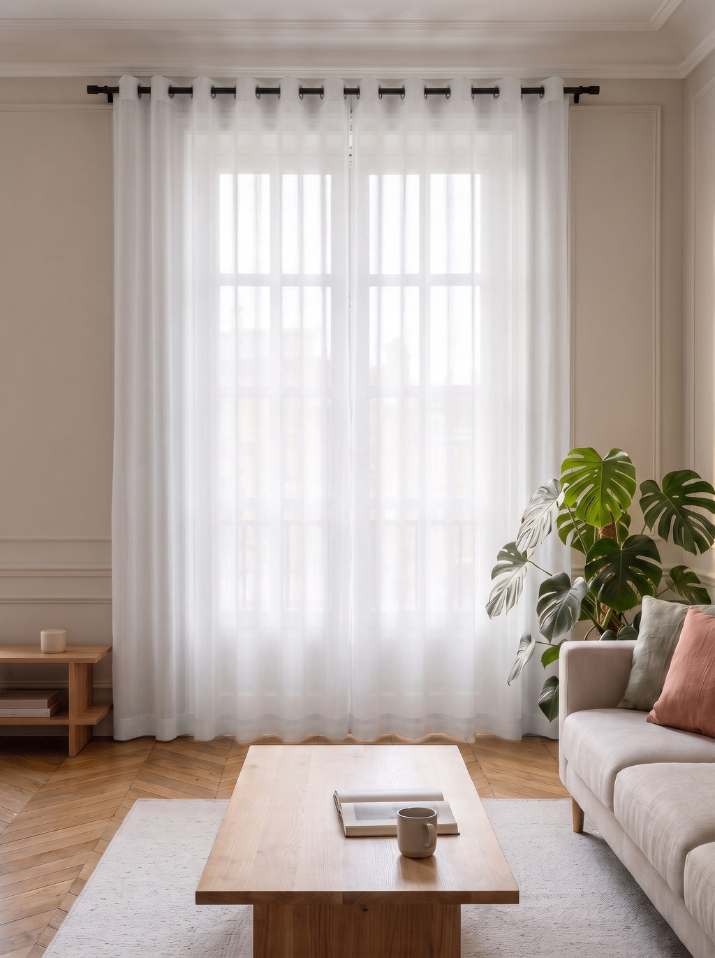 Rideau voilage en tulle blanc tiré devant la fenêtre d'un salon, la lumière du jour traverse le voile