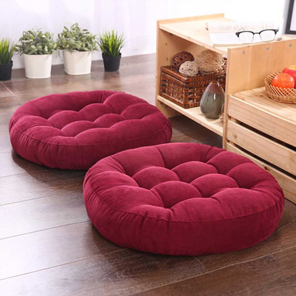 Coussin de sol rond bordeaux, deux exemplaires posés sur un parquet