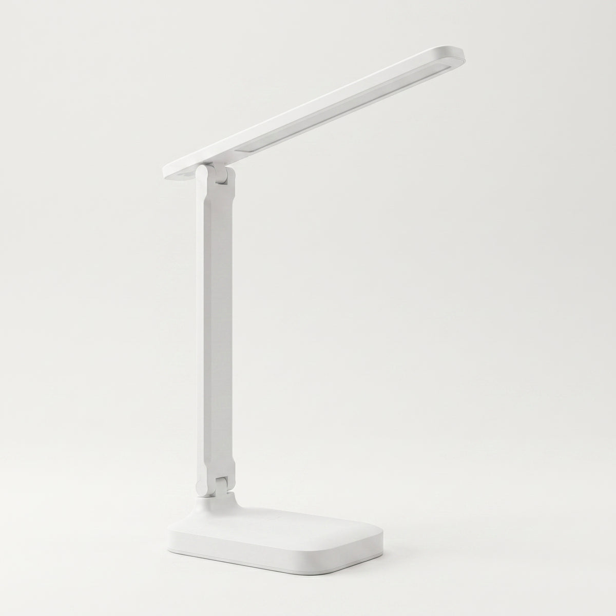 Lampe de bureau LED blanche déployée sur fond blanc cassé