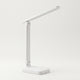 Lampe de bureau LED blanche déployée sur fond blanc cassé