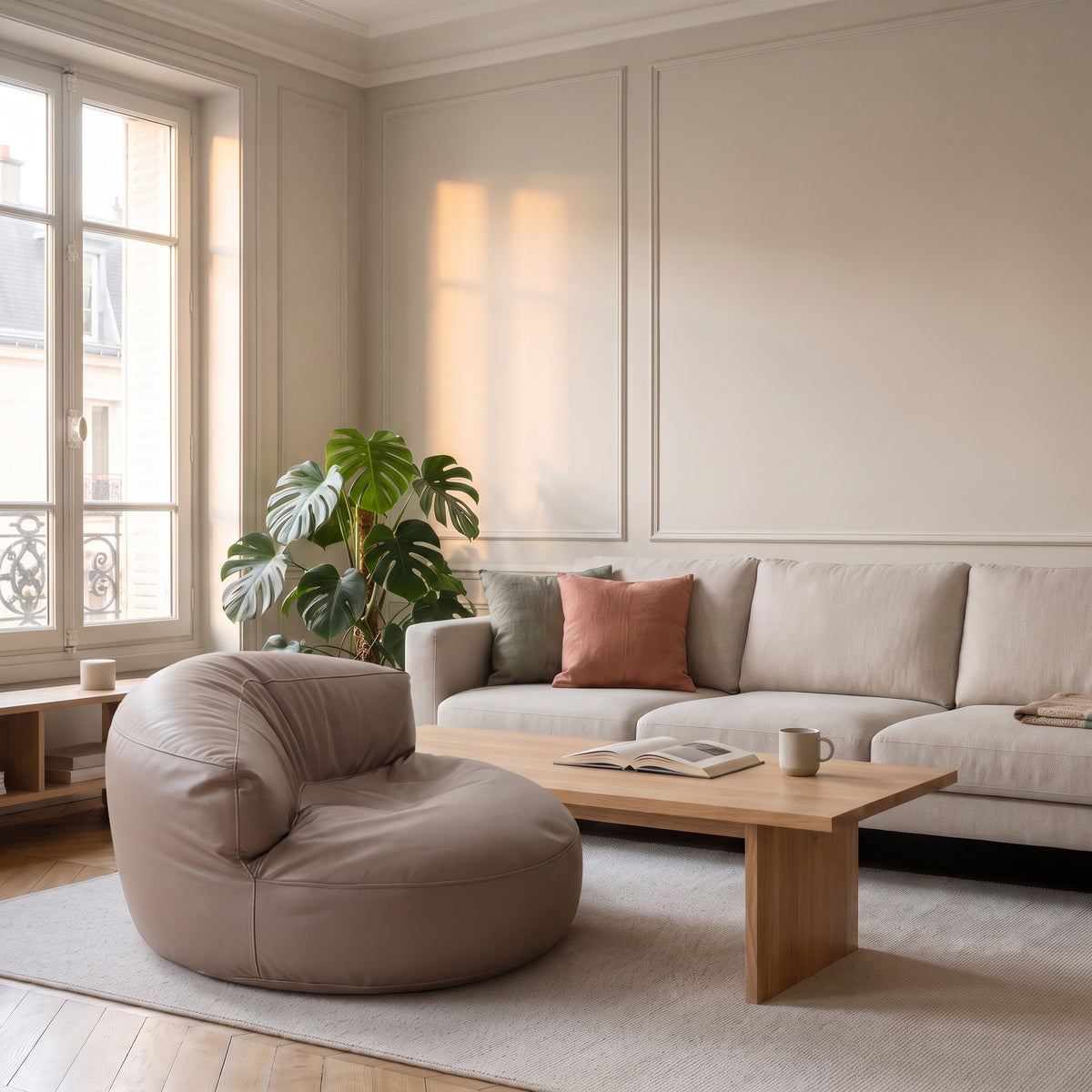 Pouf fauteuil taupe en cuir synthétique devant un canapé