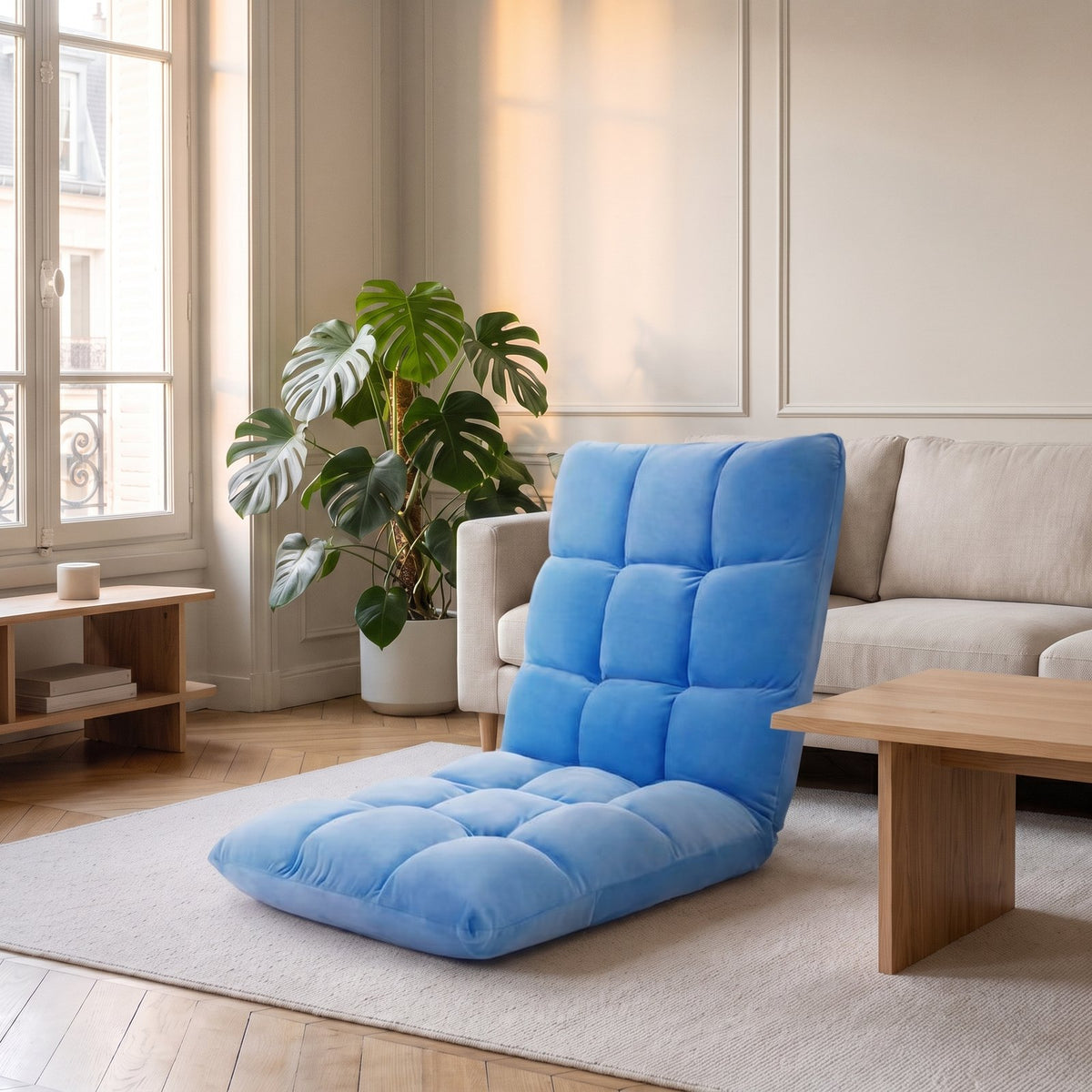 Fauteuil de sol bleu posé sur le tapis, au pied d'un canapé