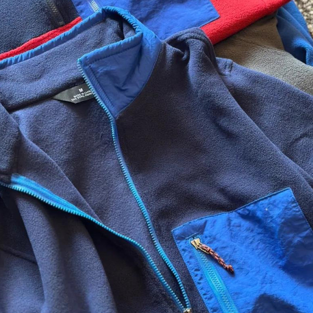 Détail du demi-zip et de la poche poitrine contrastée