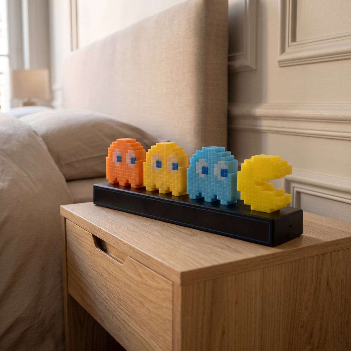Gros plan sur les figurines pixel de la lampe Pac Man et leur socle noir