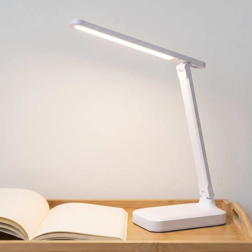 Lampe de bureau LED blanche orientée vers un livre sur une table en bois clair