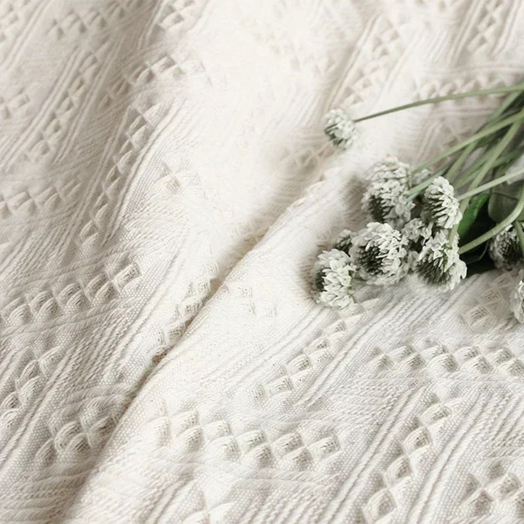 Motifs géométriques en relief du plaid blanc cassé vus de près