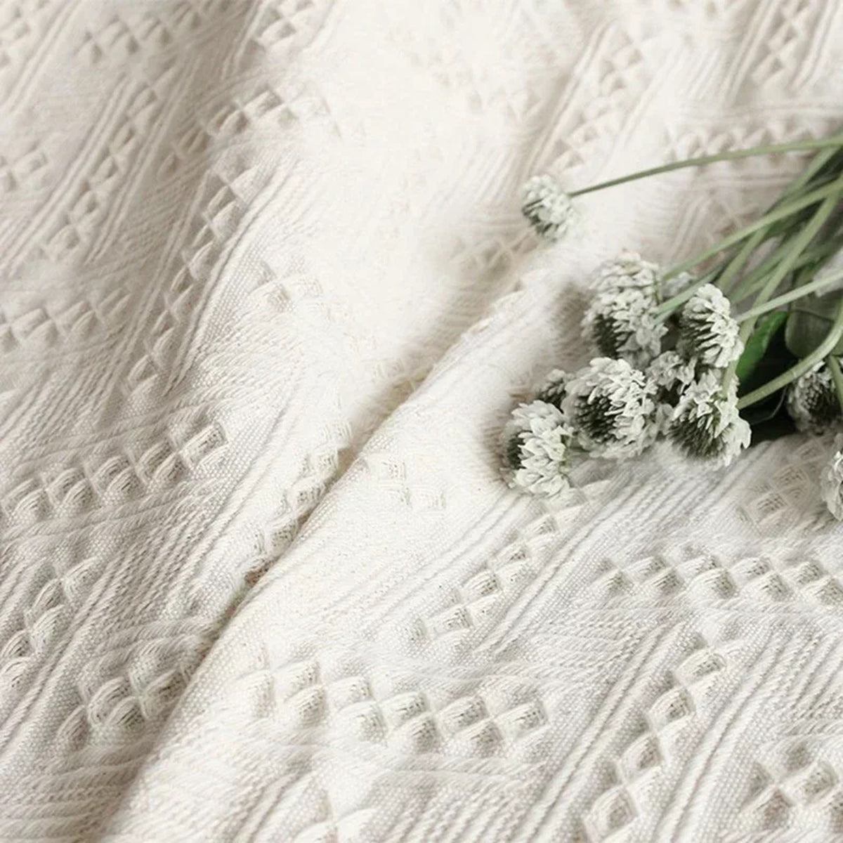 Motifs géométriques en relief du plaid blanc cassé vus de près