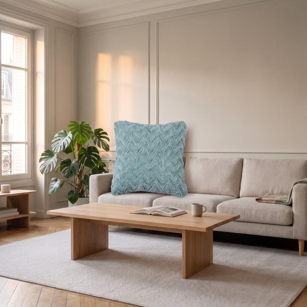 Coussin en coton vert d'eau posé dans l'angle d'un canapé