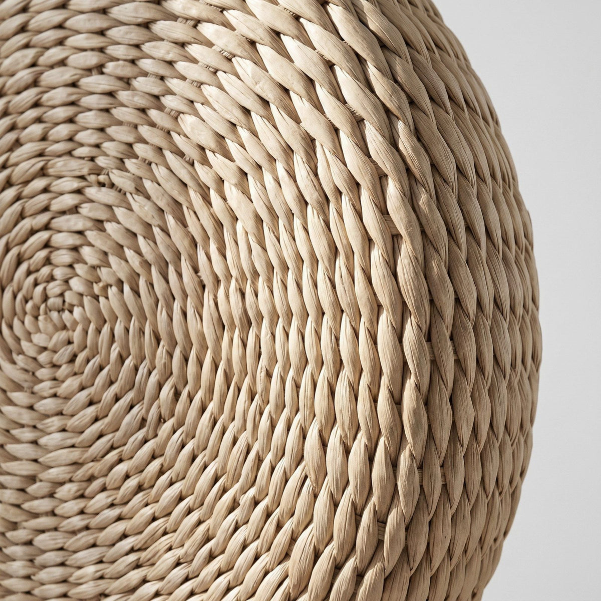 Détail du cordon de paille enroulé en spirale sur le dessus du coussin