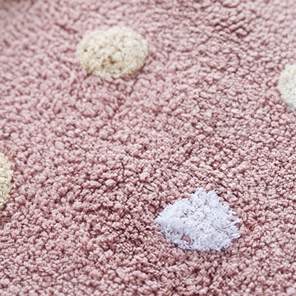 Gros plan sur les pois tuftés en relief du tapis rond en coton