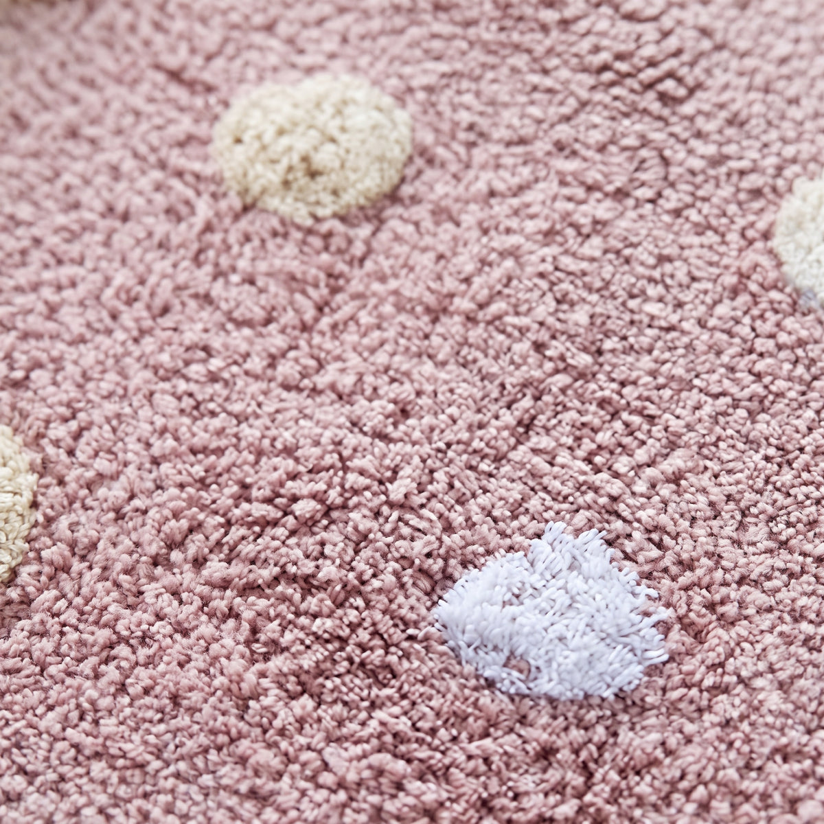 Gros plan sur les pois tuftés en relief du tapis rond en coton