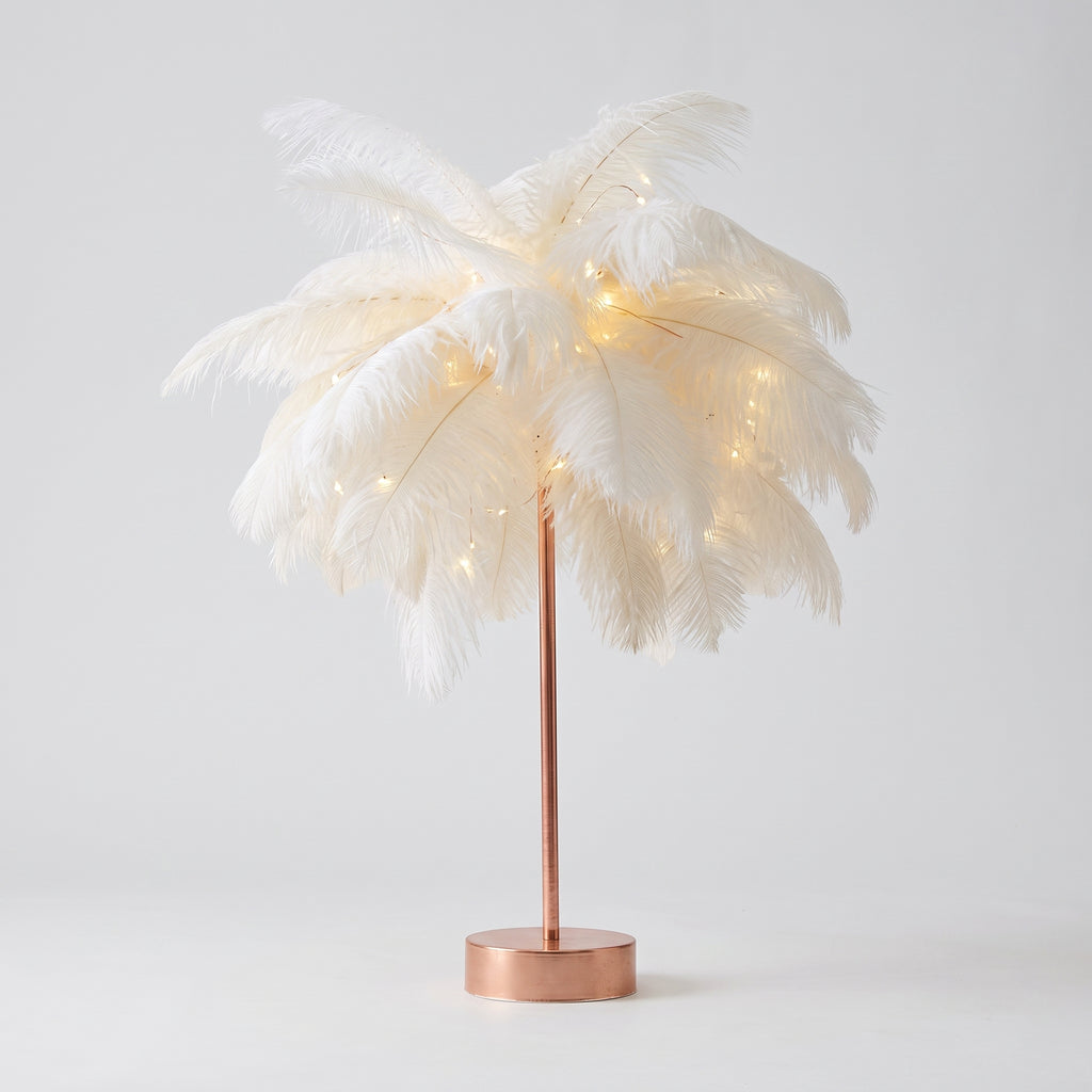 Lampe à plumes blanches entière, socle doré rose, sur fond gris clair