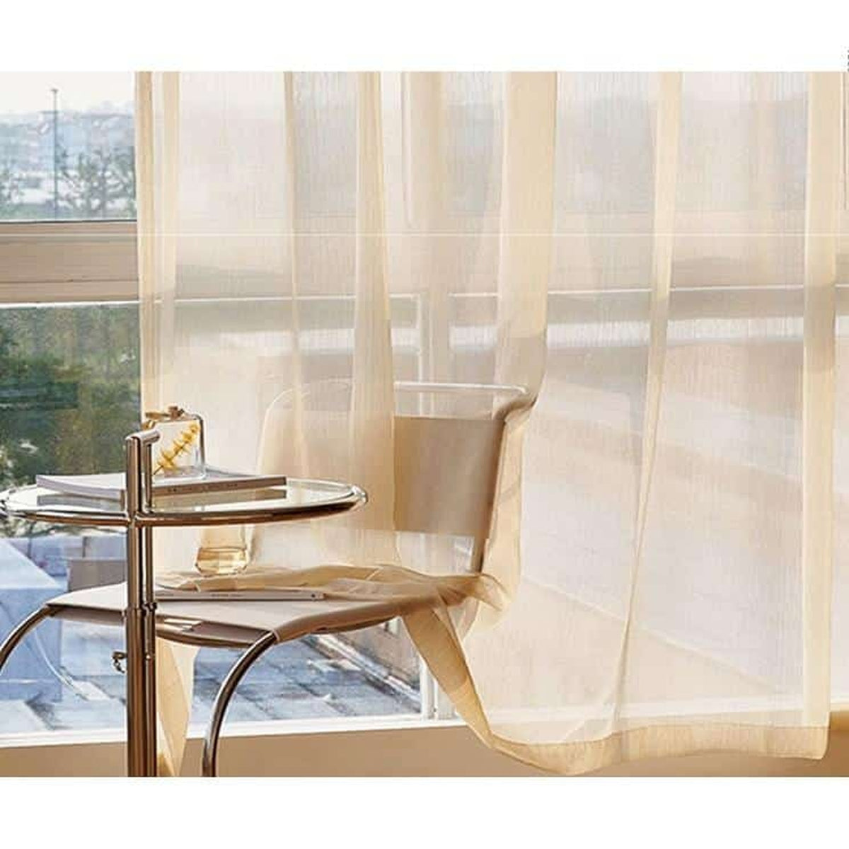 Voilage translucide argenté devant une fenêtre et une table ronde