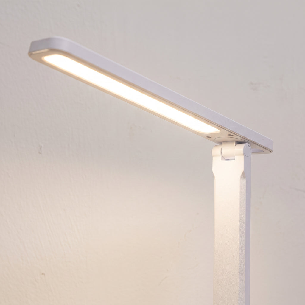 Détail de la tête allumée et de l’articulation de la lampe de bureau LED
