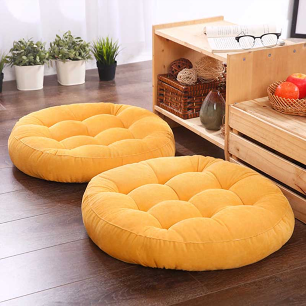 Coussin de sol rond jaune moutarde, deux exemplaires posés sur un parquet