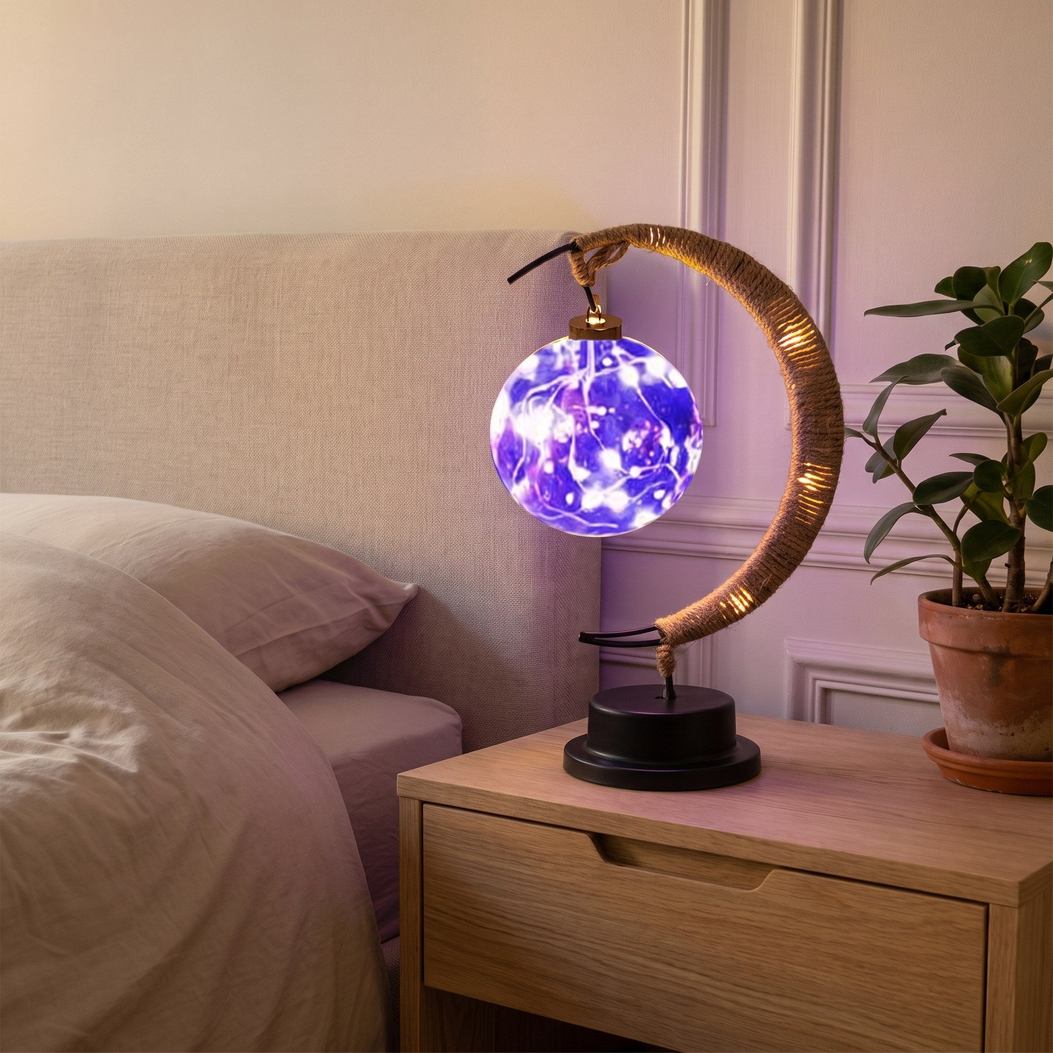 Lampe croissant de lune allumée en violet, halo coloré sur le mur de la chambre. Image