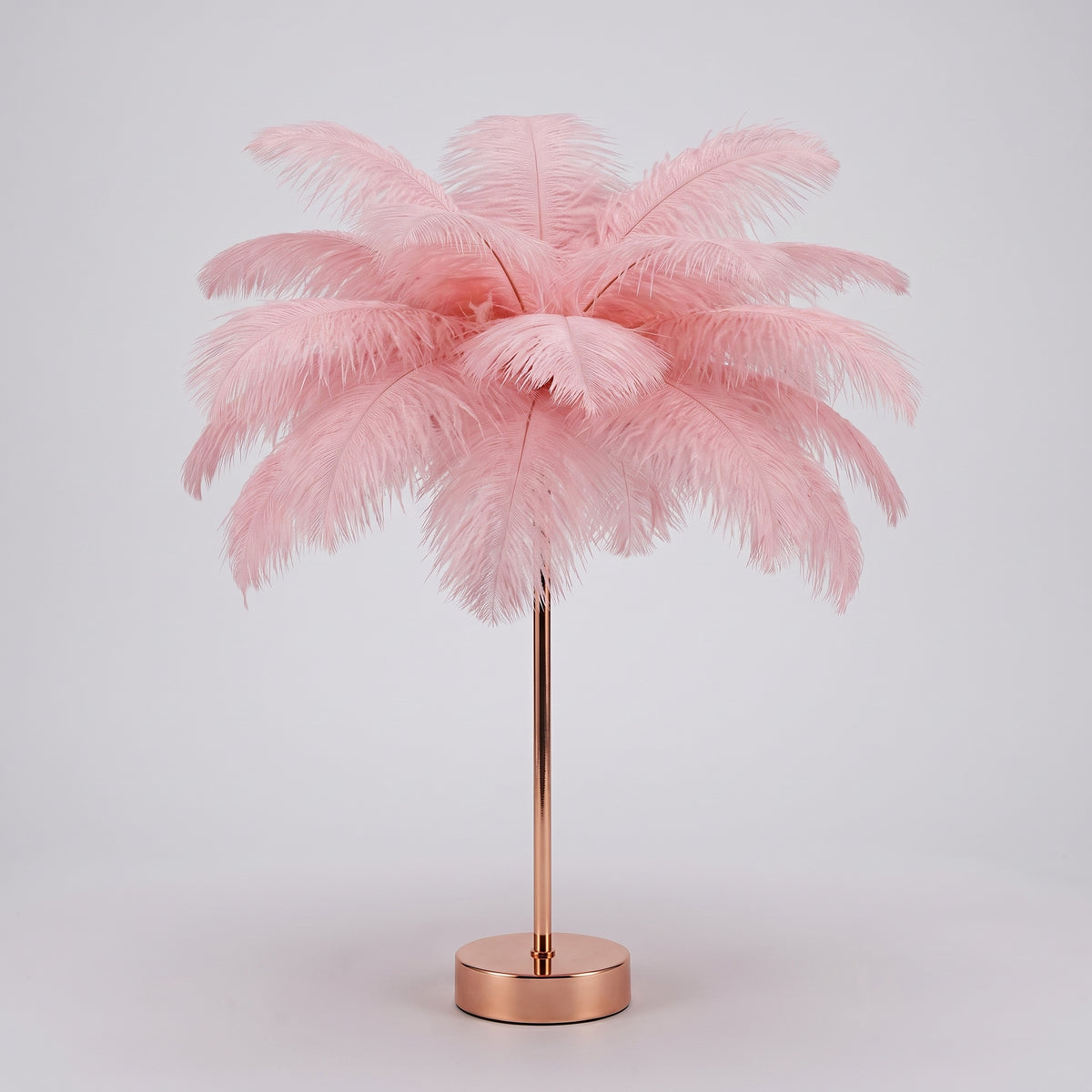 Lampe à plumes roses entière, socle doré rose, sur fond gris clair