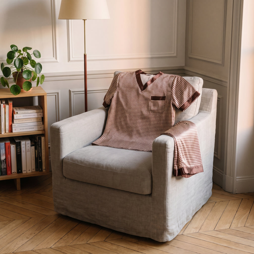 Haut du pyjama en satin pied-de-poule déplié sur un fauteuil, le short plié sur l'accoudoir