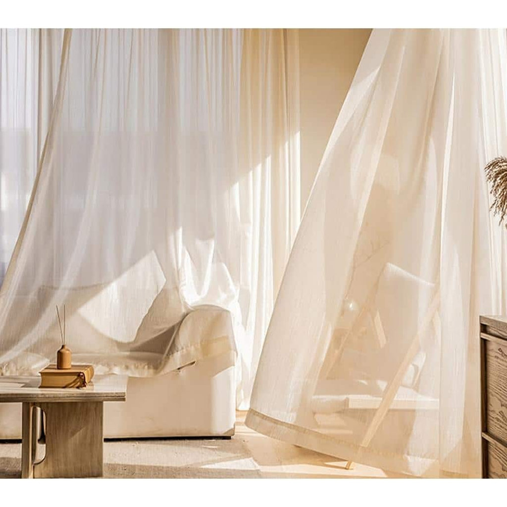 Voilage doré ouvert dans un salon lumineux, du haut de la fenêtre au sol