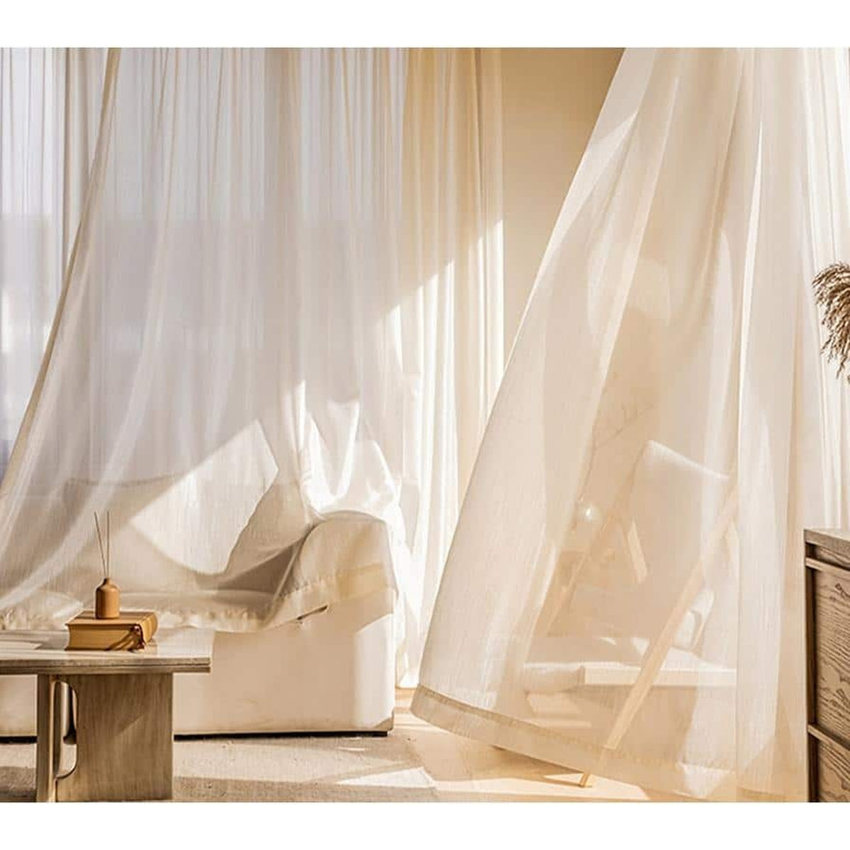 Voilage doré ouvert dans un salon lumineux, du haut de la fenêtre au sol