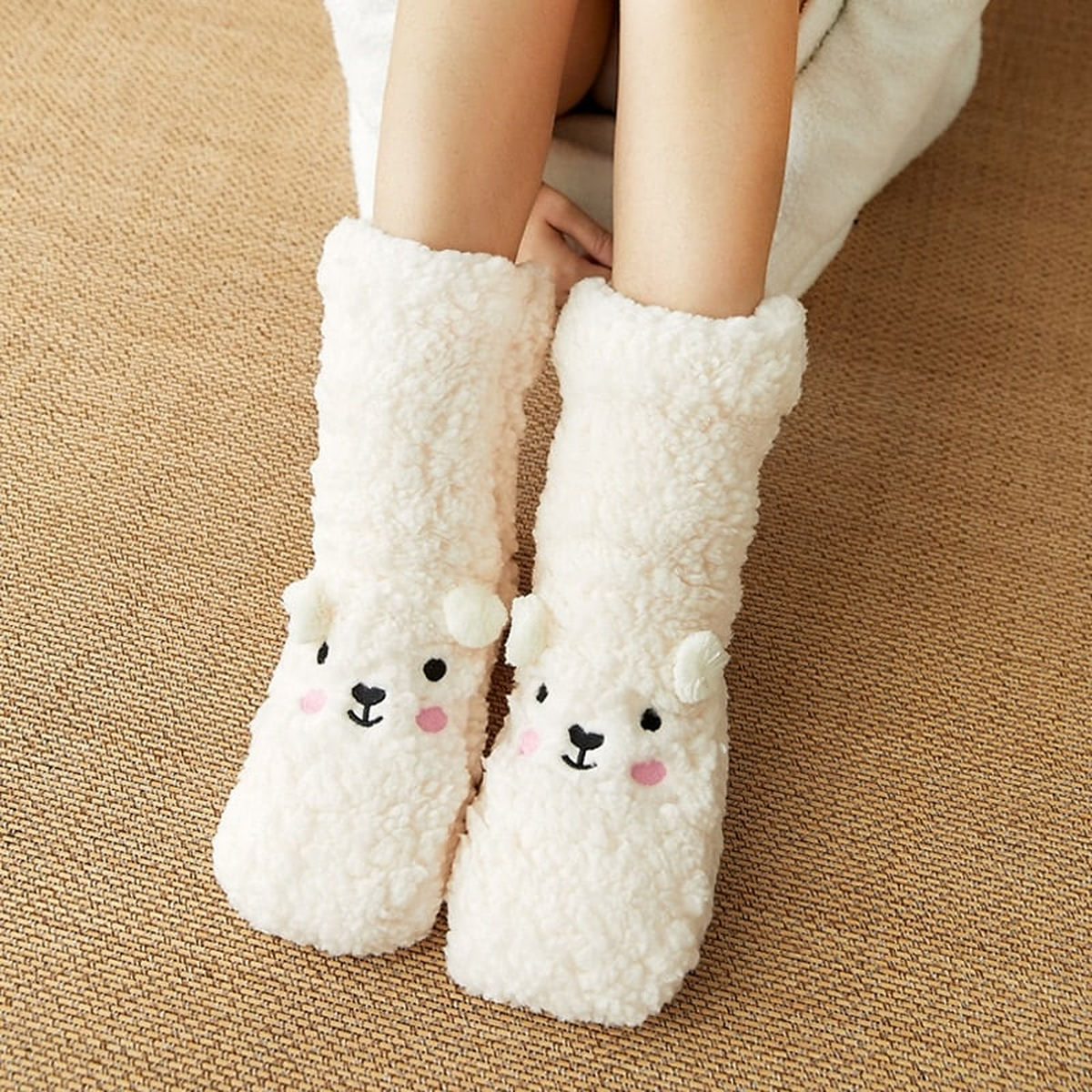 Chaussettes ourson blanches portées, texture bouclée et motif brodé
