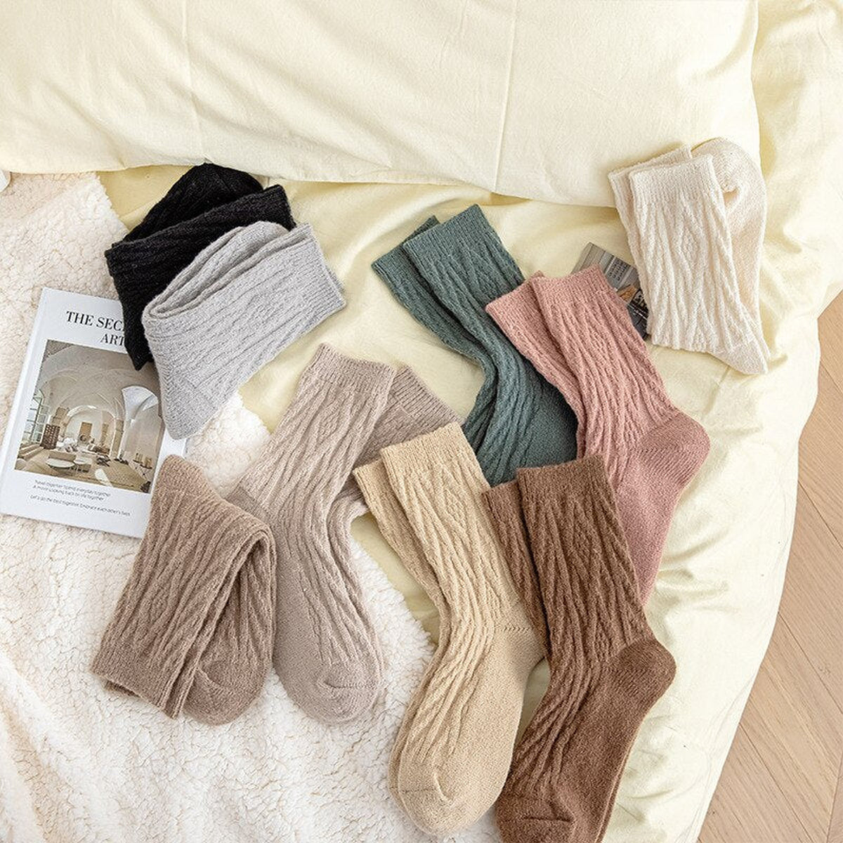 Neuf paires de chaussettes tricotées disposées sur un lit