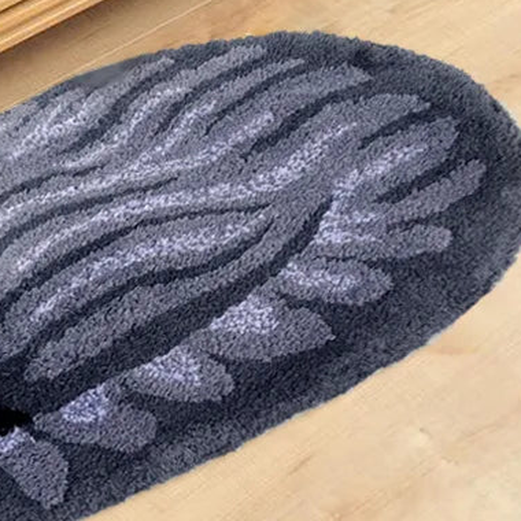 Gros plan sur les fibres et les rayures du tapis chat gris