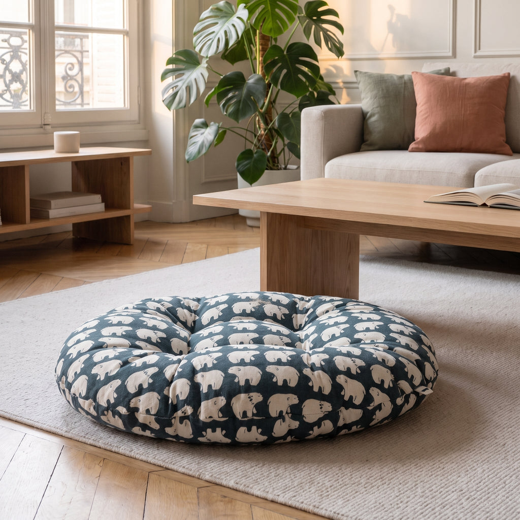 Coussin de sol rond imprimé ours polaires sur fond bleu nuit, posé sur un tapis clair