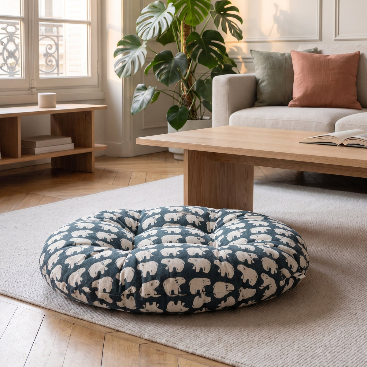 Coussin de sol rond imprimé ours polaires sur fond bleu nuit, posé sur un tapis clair