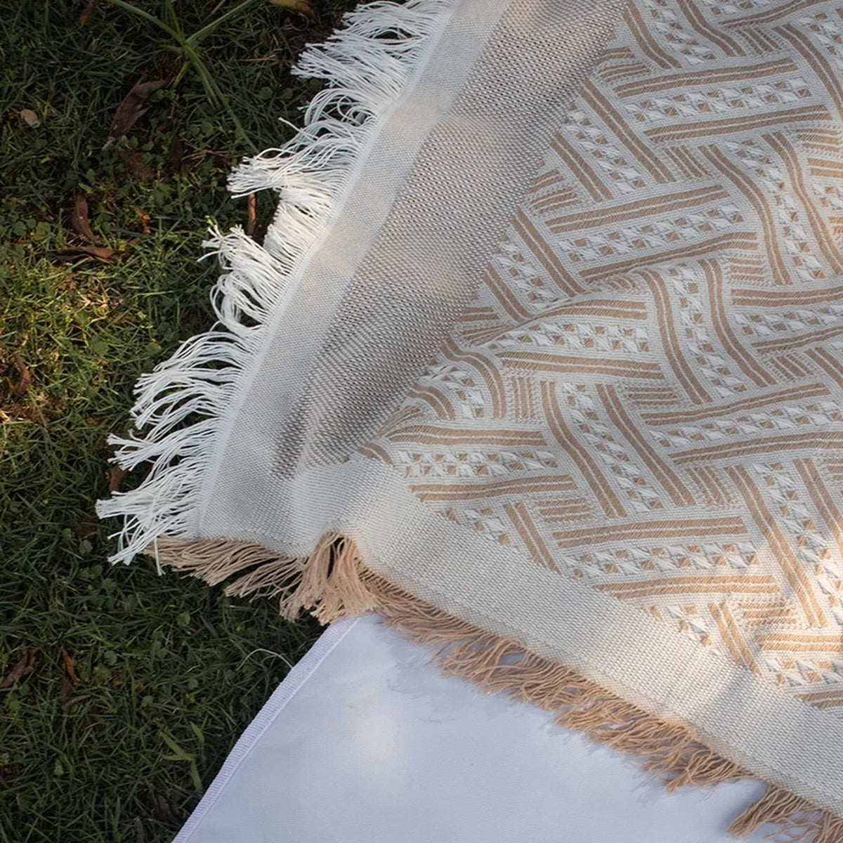 Bords frangés et motifs en relief du plaid beige vus de près