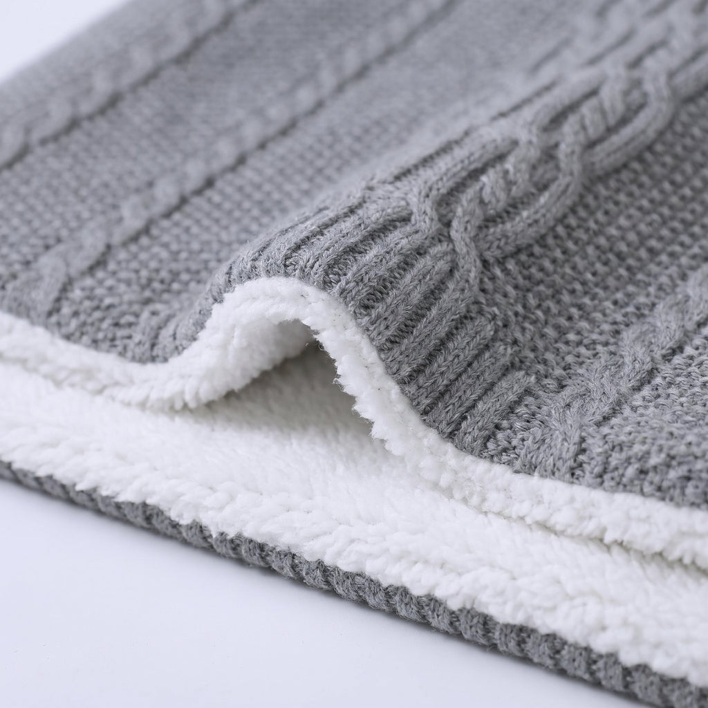 Bord replié de la gigoteuse, maille torsadée grise dessus et peluche blanche dessous
