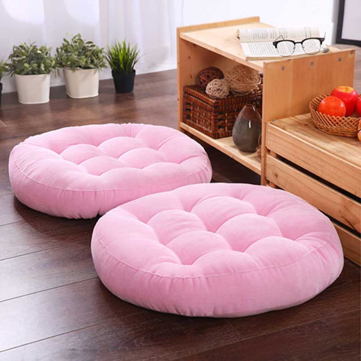 Coussin de sol rond rose, deux exemplaires posés sur un parquet