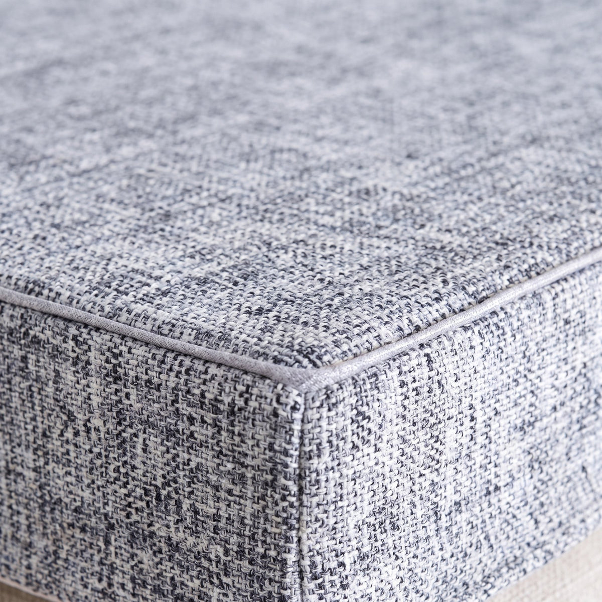 Tissu chiné et passepoil du coussin de sol, vus de près