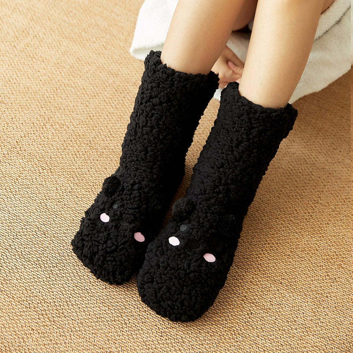 Chaussettes ourson noires portées, joues roses et motif brodé