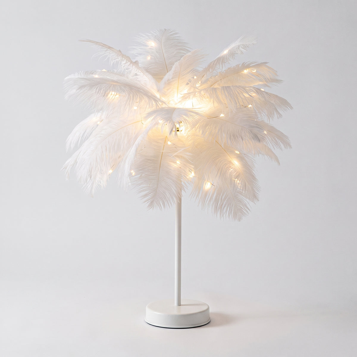 Lampe à plumes blanches entière, socle blanc, sur fond gris clair