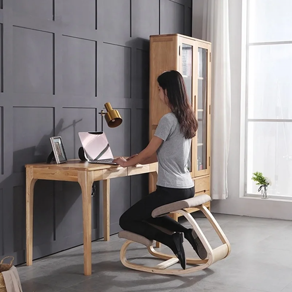 Chaise à genoux ergonomique utilisée face à un bureau en bois