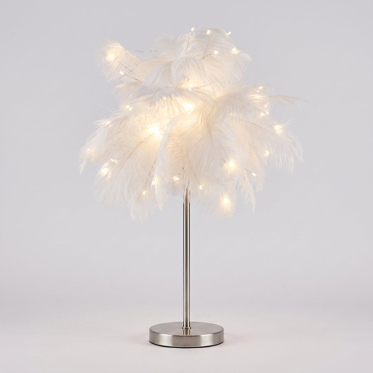 Lampe à plumes blanches entière, socle argenté, sur fond gris clair