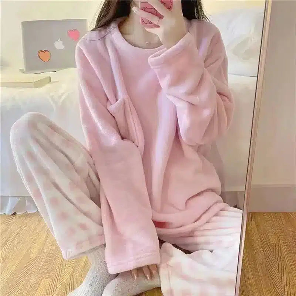 Femme en pyjama rose à carreaux dans un intérieur clair