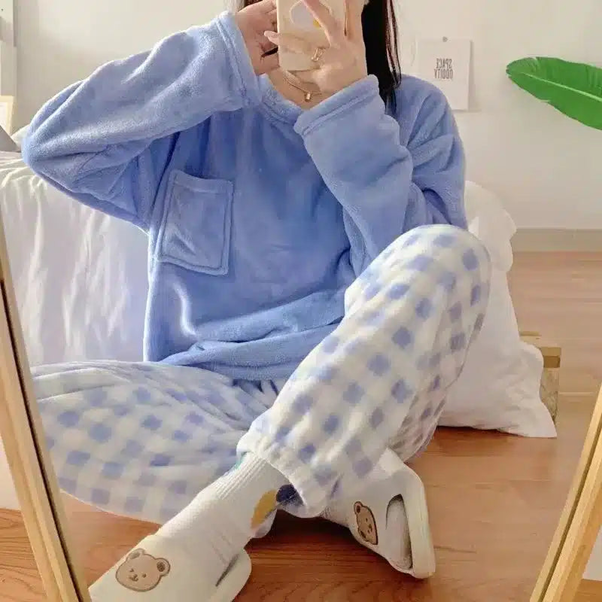Femme en pyjama bleu lavande à carreaux dans un intérieur clair