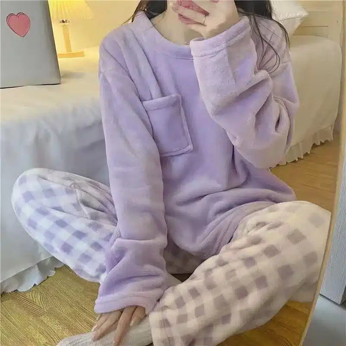 Femme en pyjama lilas à carreaux dans un intérieur clair