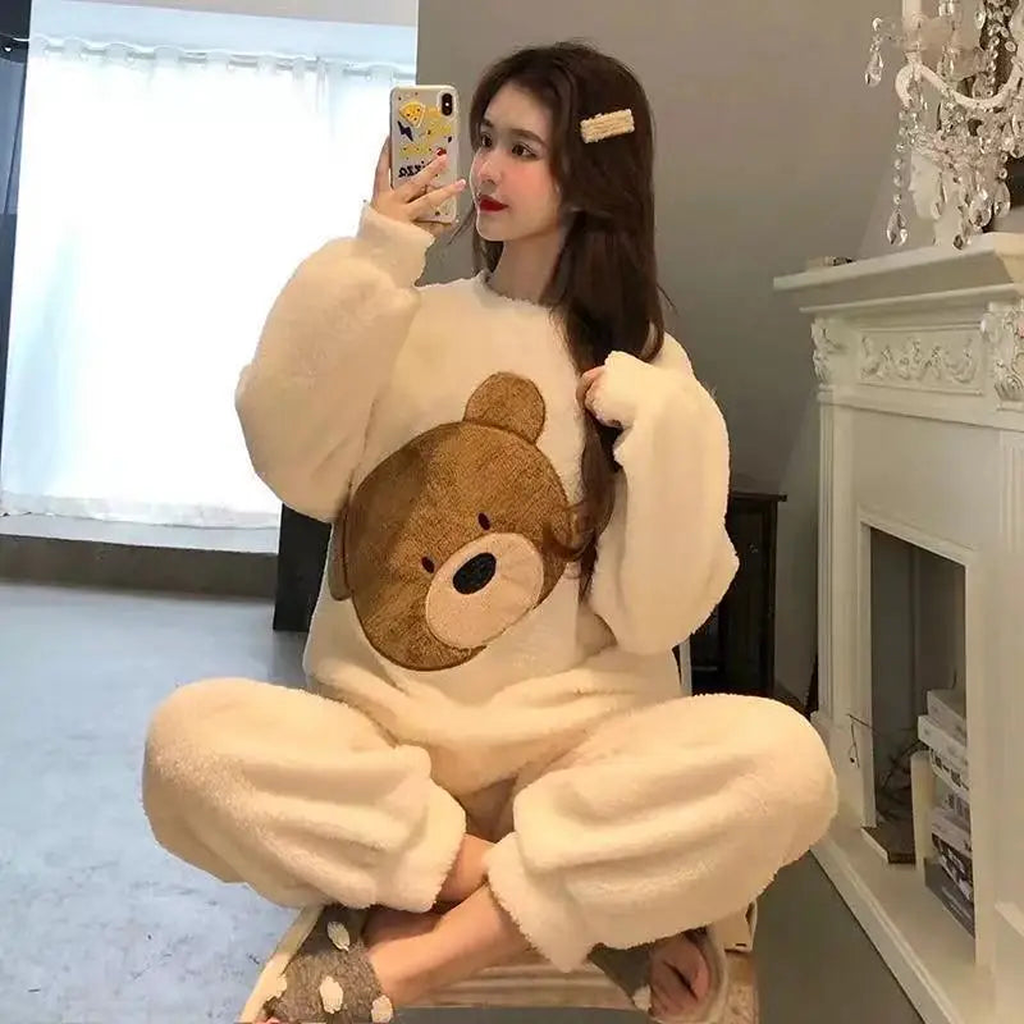 Femme en pyjama beige grand ours dans un intérieur clair