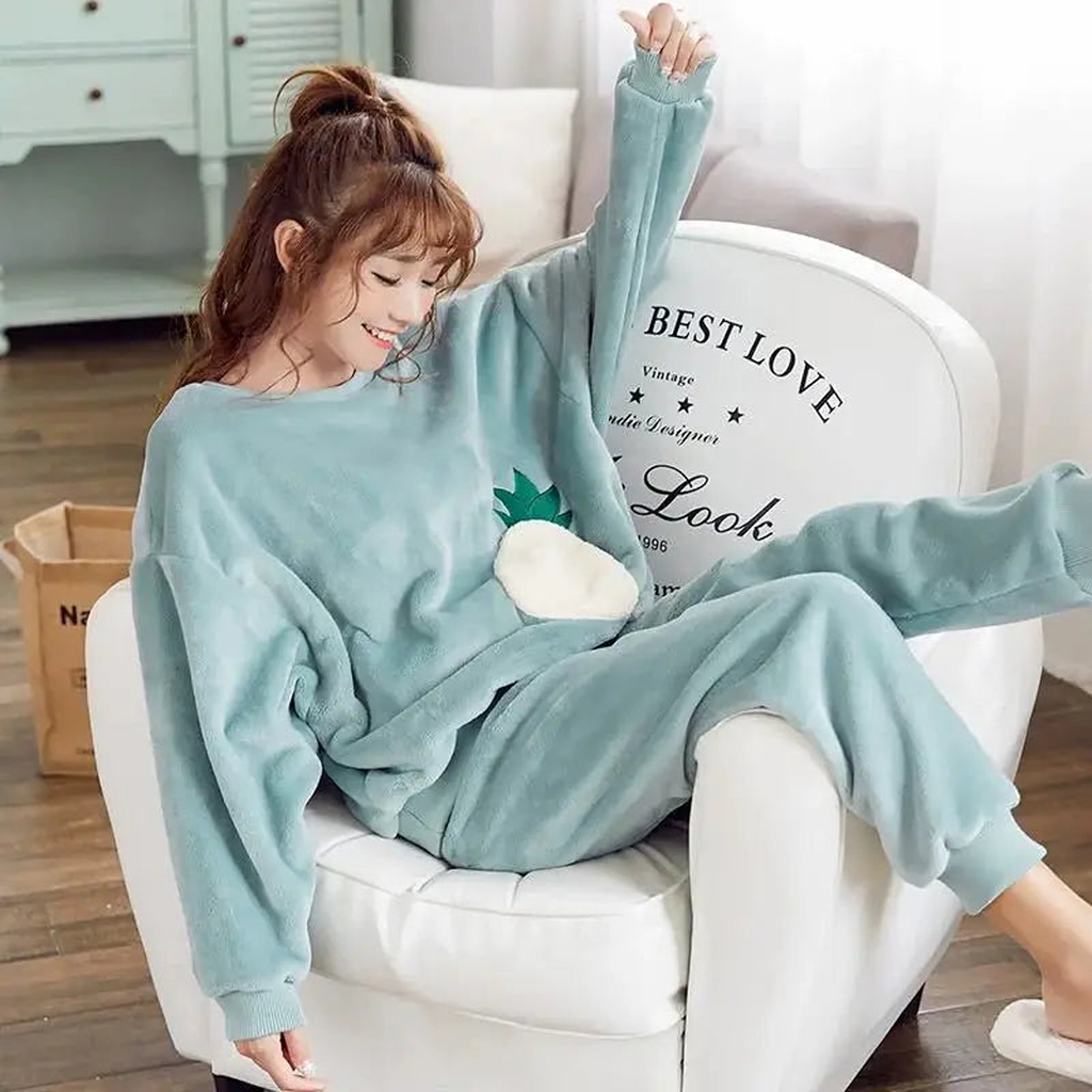 Femme en pyjama vert d'eau uni dans un intérieur clair