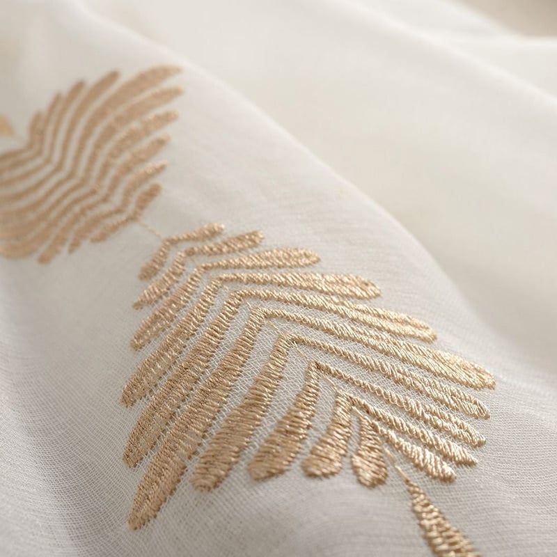 Broderie de feuillages beige doré en relief sur le voile de coton
