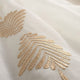 Broderie de feuillages beige doré en relief sur le voile de coton