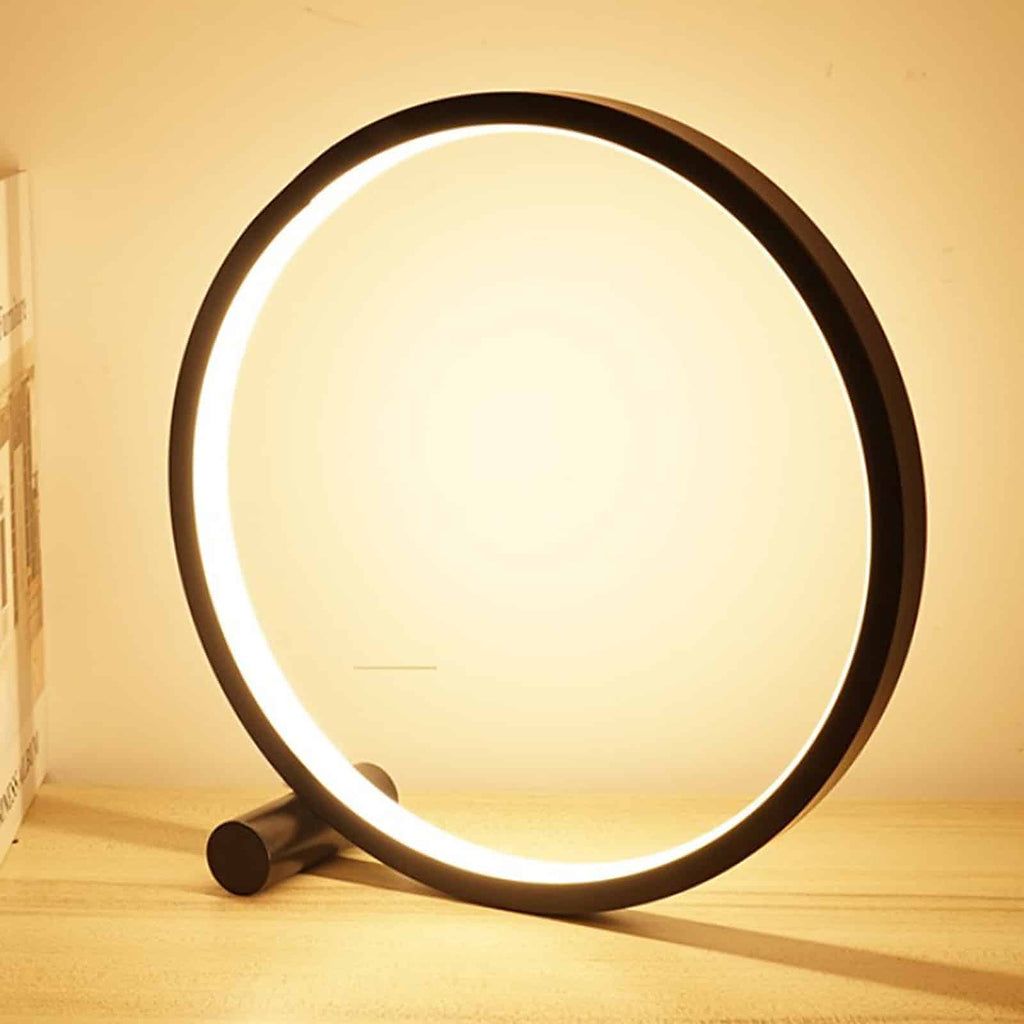 Lampe de table LED circulaire noire allumee, vue de face