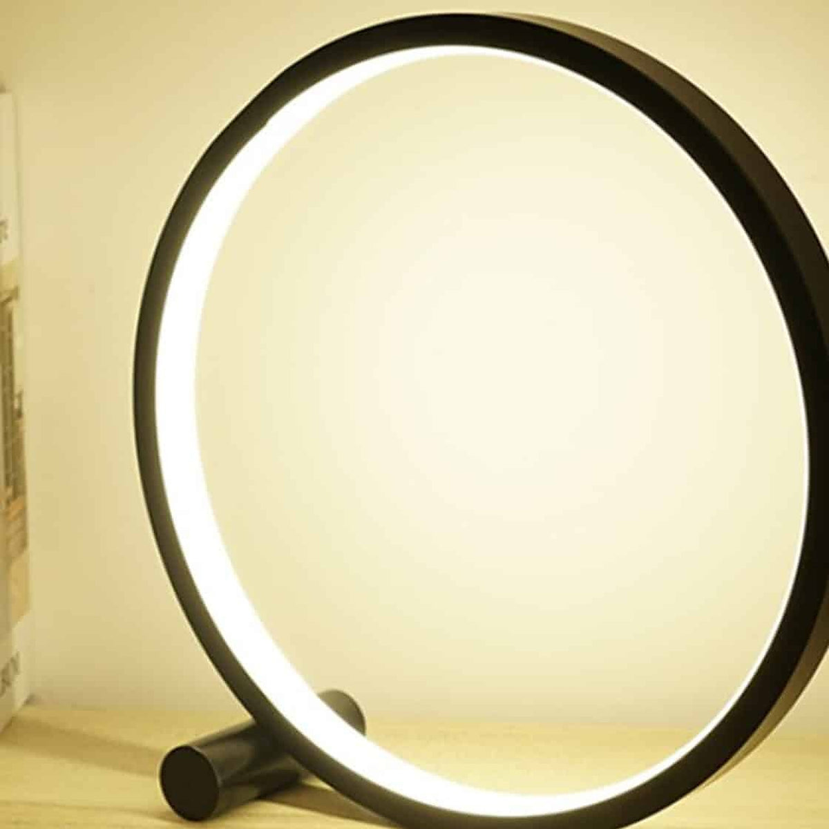 Lampe de table LED circulaire noire, halo chaud du soir Image