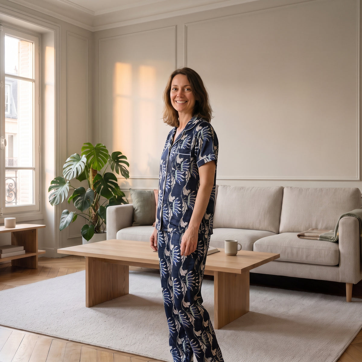 Pyjama trois pièces en viscose à feuillage bleu marine, porté debout dans un salon