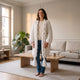 Gilet long en grosse maille torsadée, coloris Blanc cassé, porté dans un salon